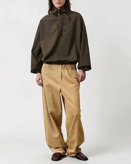 ALYSI カーキのアノラックジャケットの全身着用、ベージュのパンツとのコーディネート