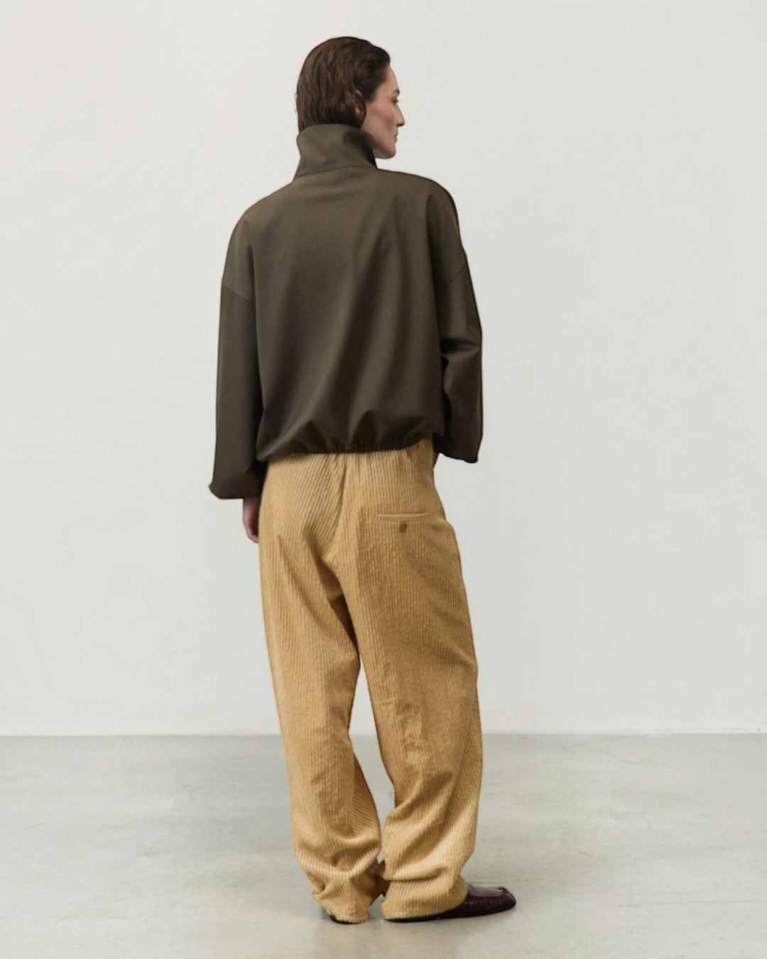 ALYSI カーキのアノラックジャケットの背面着用、ゆったりした背中と裾のシルエット