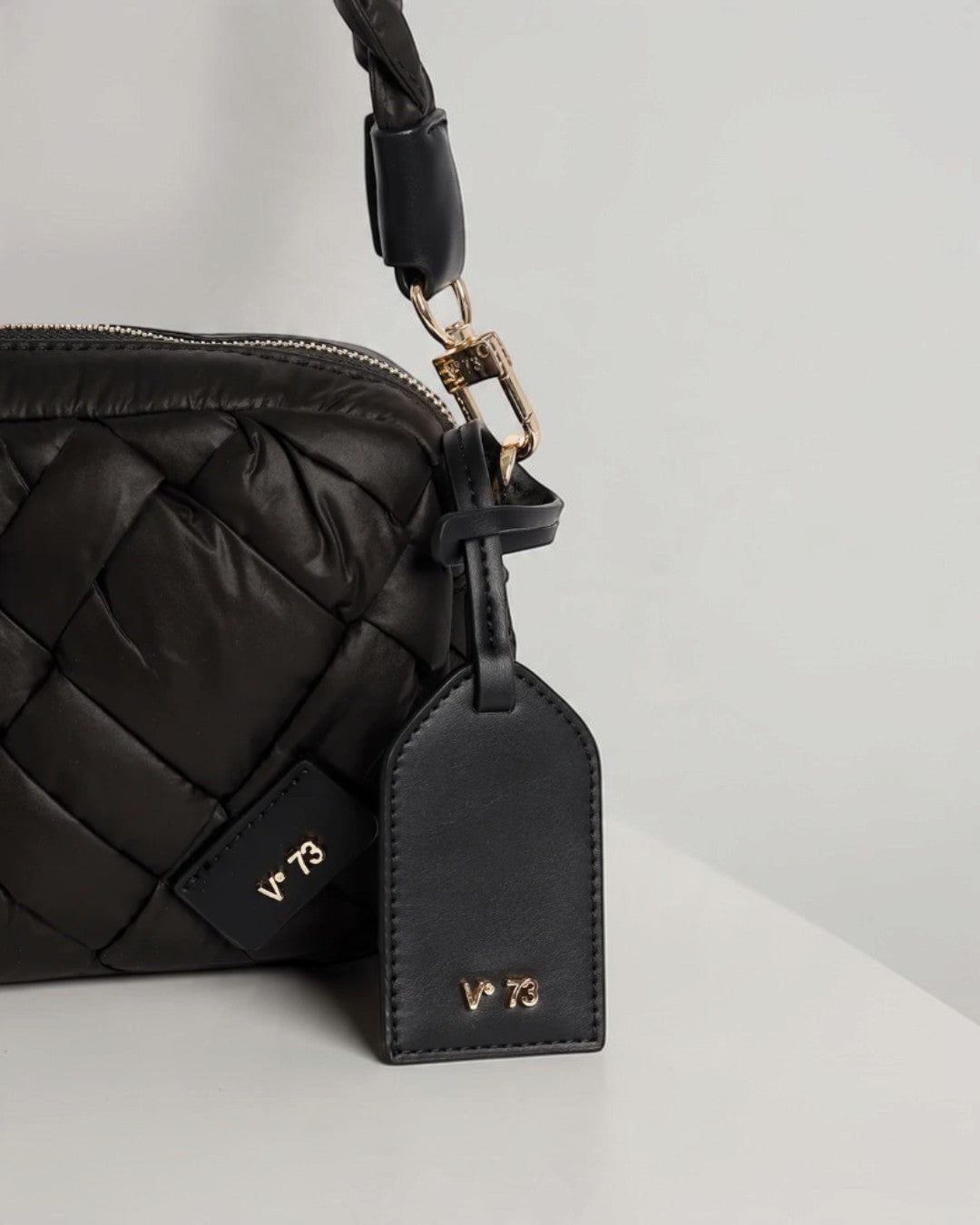 V°73 ブラックのミニショルダーバッグのロゴチャームタグとゴールドのハンドル接続金具