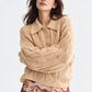 Scotch & Soda ベージュのケーブル編みポロニット、腕を組んだ上半身の着用イメージ